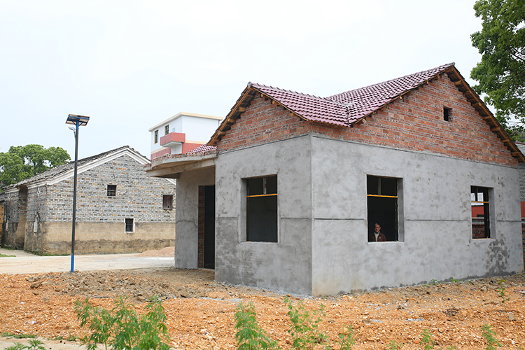 4.在旧房旁边，政府出部分资金为张小蕾家建了房子。“现在没有钱继续建了，只能暂时搁置。”张小蕾爷爷说。.JPG